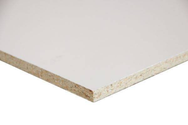 Close-up of the corner of a white laminated particle board panel showing the beige core edge